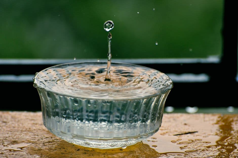 A water droplet splashing in a clear glass bowl