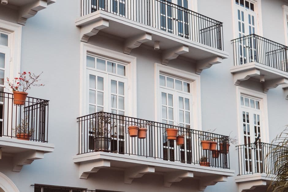 A modern building with balconies and potted plants