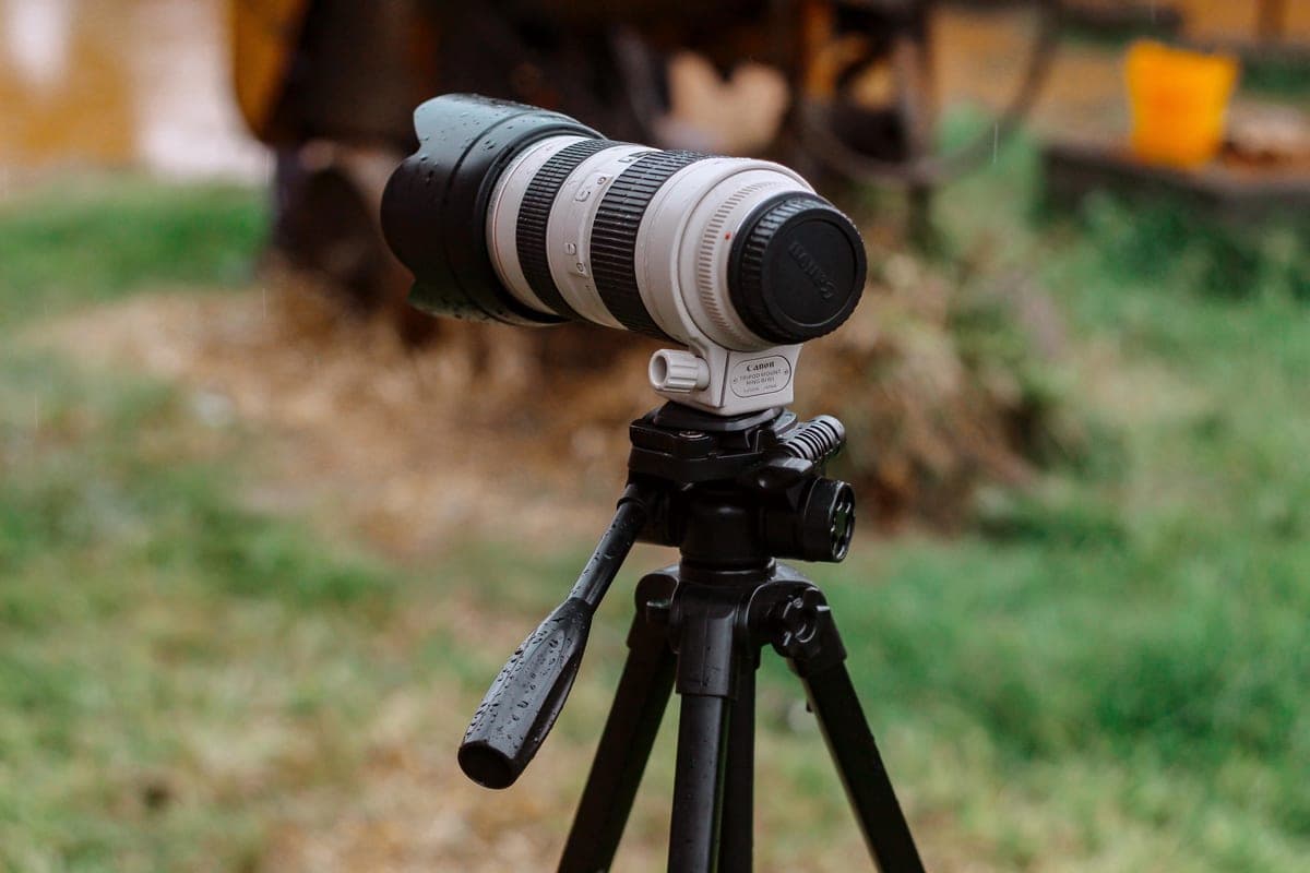 A camera lens on a tripod outdoors