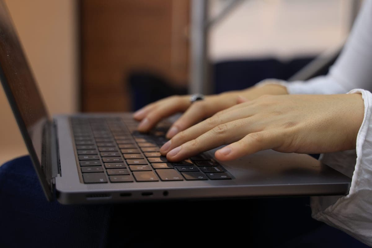Hands typing on a laptop keyboard