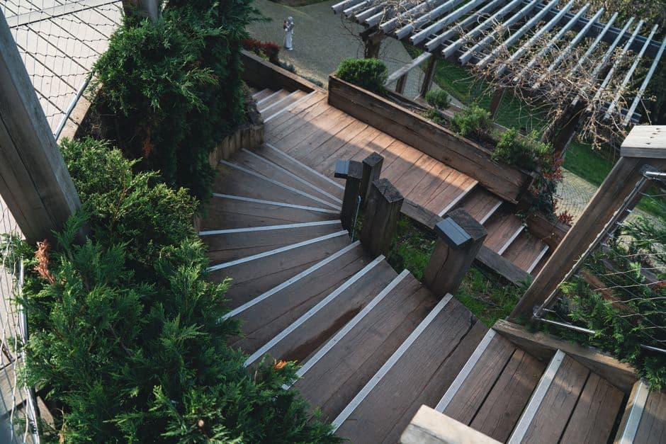A wooden deck railing in a leafy garden