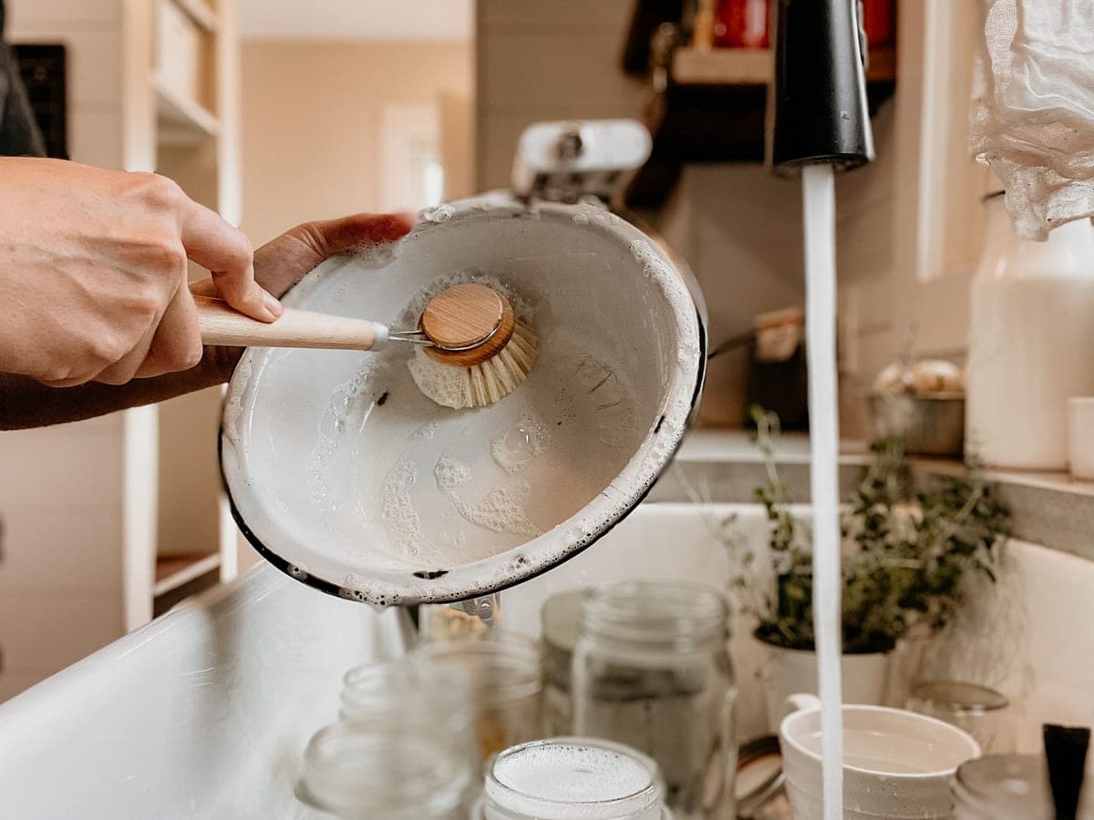 A jar being scrubbed with a brush