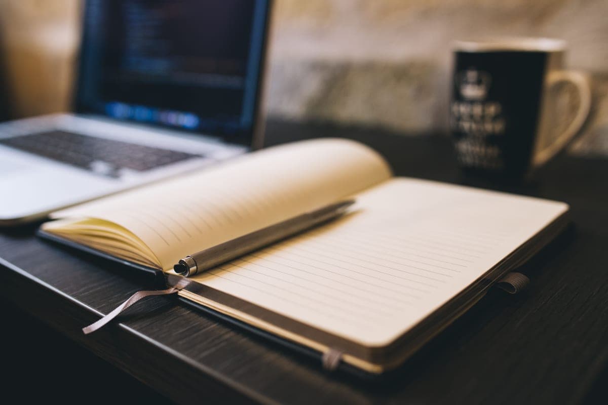 An open notebook and pen on a desk