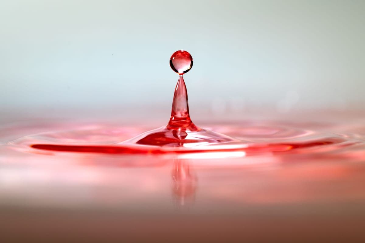 A drop of red food coloring dispersing in water